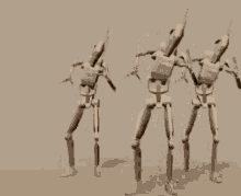 three robots are standing next to each other with their arms up in the air .