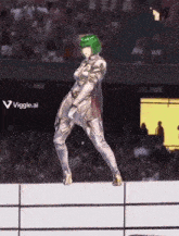 a woman with green hair is standing on a wall in front of a crowd of people .
