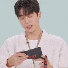 a young man is holding a card that says netflix