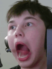 a young boy wearing headphones with his mouth open .