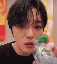 a young man is drinking from a sprite bottle