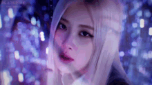 a close up of a woman 's face in front of a blurry background of lights .