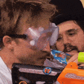 a man wearing goggles is drinking from a can of carlsberg
