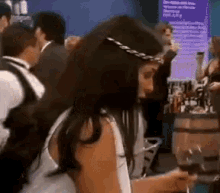 a woman holding a glass of wine in front of a crowd