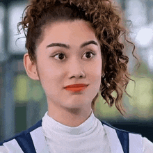 a close up of a woman 's face with a ponytail and red lipstick