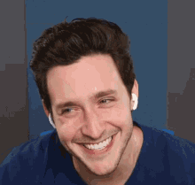 a man wearing headphones is smiling with his eyes closed and his mouth open .