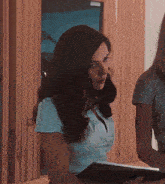 a woman in a white shirt is looking at a tablet