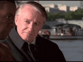 a man in a suit and tie is looking at another man
