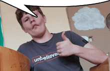 a boy wearing a t-shirt that says unbelievable giving a thumbs up