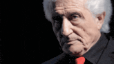 a man with gray hair is wearing a red tie