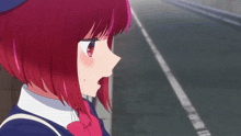 a girl with red hair and a blue hat is standing on a street