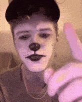 a young man with his face painted like a dog