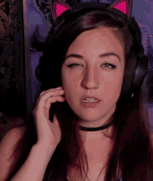 a woman wearing headphones and a cat ear choker