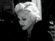 a black and white photo of a woman with blonde hair .