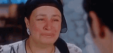 a woman is crying and looking at a man in a movie .