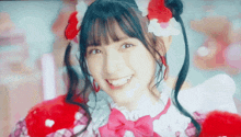 a girl with pigtails is smiling and wearing a costume with hearts on it