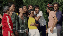 a group of men are posing for a picture and one man is wearing a yellow shirt