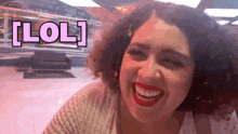 a woman with curly hair is smiling with the word lol above her head