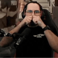 a man wearing glasses and headphones holds his fist up