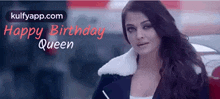 a woman with long hair is standing in front of a car with the words happy birthday queen written on the bottom .