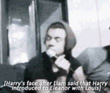 a man in a hoodie is talking into a microphone .