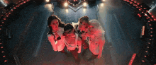 a group of women are standing next to each other on a stage in a dark room .
