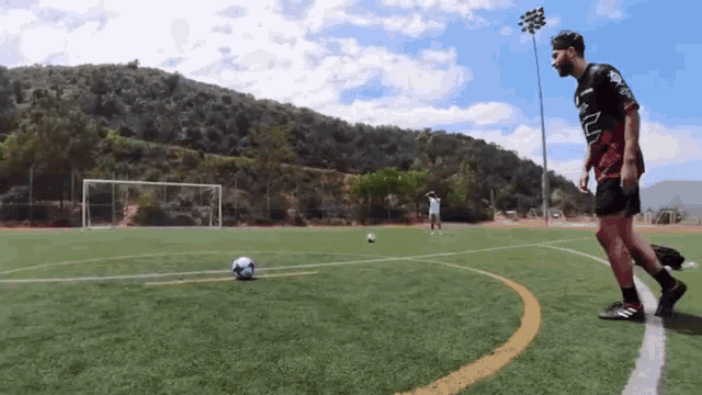 soccer player kicking ball into goal