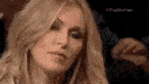 a close up of a woman with long blonde hair making a funny face .