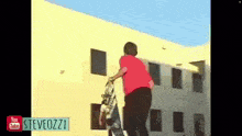 a man is doing a trick on a skateboard in front of a yellow building ..