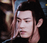 a close up of a man with long hair