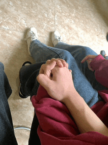 a person holding another person 's hand while sitting on their lap