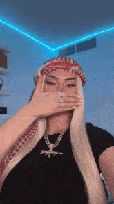 a woman wearing a scarf and a necklace with a gun on it