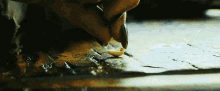 a close up of a person 's hand holding a small yellow object