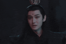 a man with long black hair and a crown on his head .