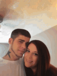 a man and a woman are posing for a picture and the woman has a tattoo on her neck