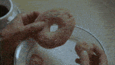 a person is holding a donut with powdered sugar on it in their hands