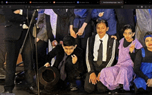 a group of people are posing for a picture with the website showing in the upper left corner