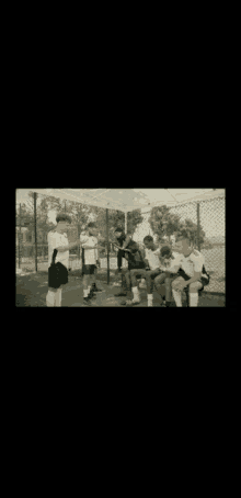a group of soccer players are sitting under an umbrella talking to each other