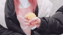 a person is holding a piece of corn in their hands .