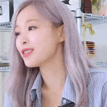 a woman with gray hair is sitting in front of a shelf .