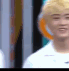 a blurry picture of a man with blonde hair and a white shirt