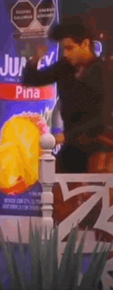 a man is standing in front of a box of pineapple juice