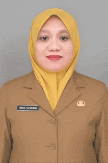 a woman wearing a yellow hijab and a tan jacket named irna fahriani