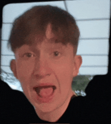 a close up of a man 's face with his mouth open