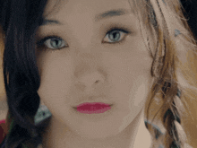 a close up of a woman 's face with blue eyes and pink lips