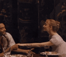 a man and a woman are dancing together and the woman is wearing a white dress