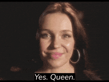a woman with hoop earrings is smiling with the words yes queen below her