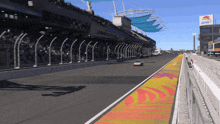 a race car is driving down a race track with a sign that says motorsports on it