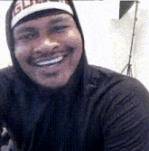 a man wearing a hoodie and a hat with the word elite on it smiles for the camera
