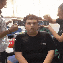 a tiktok video of a person getting their hair styled